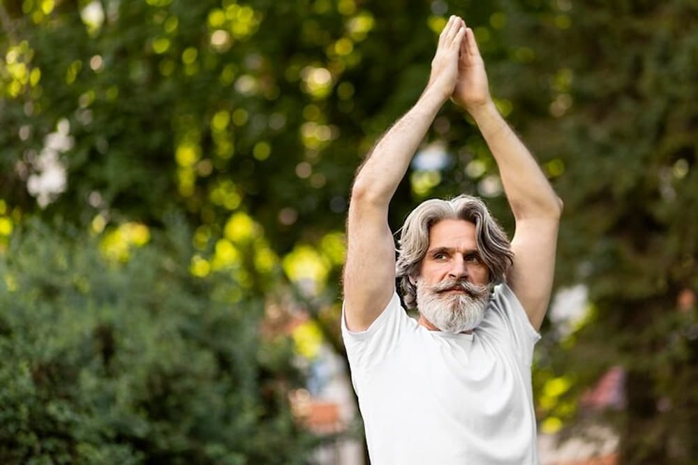 Hombre mayor meditando en exteriores