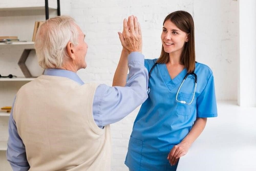 Profesional del cuidado de adulto mayores feliz junto a su paciente