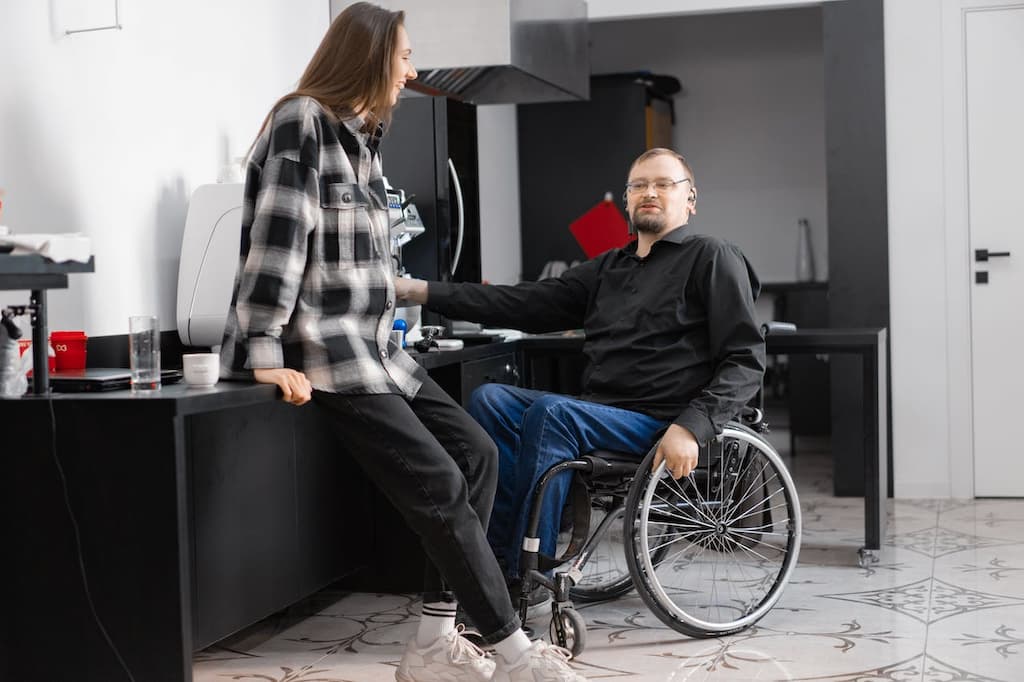 hombre en silla de ruedas con su pareja en apartamento